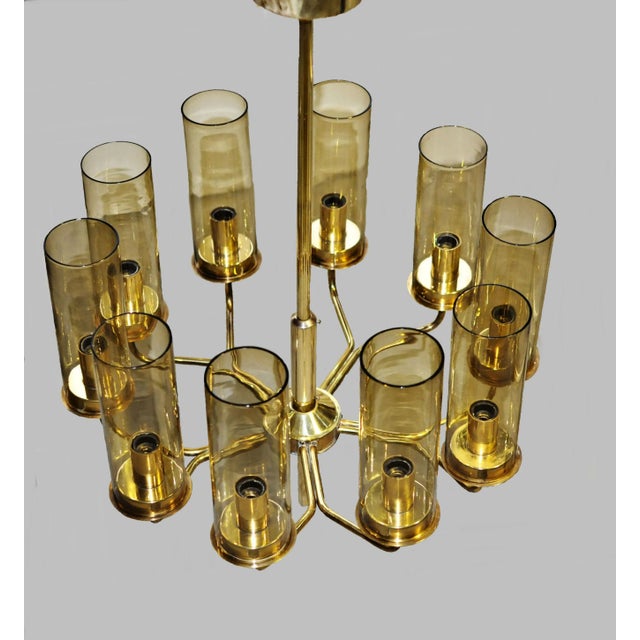 Set of two T10 chandeliers of brass with cylinder shaped shades of smoked glass, designed by Hans-Agne Jakobsson for AB in...