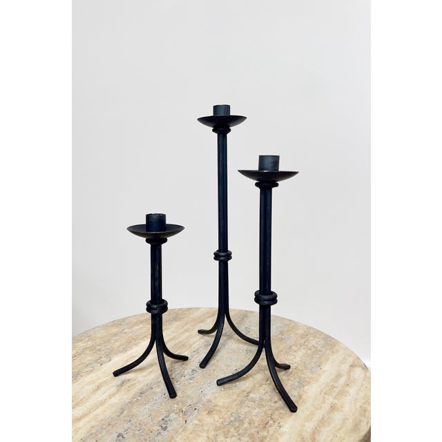 Simplistic but impactful form. Hand-forged stem with central ring or knot detail, stable tripod legs, wide drip cups, and...
