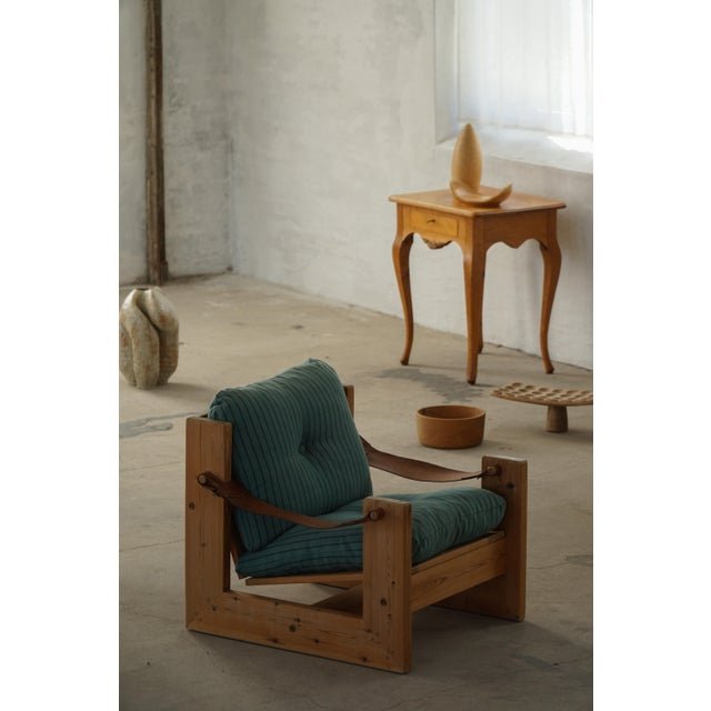A characterful pair of Swedish lounge chairs from the 1970s, crafted in solid pine with a robust and architectural frame....