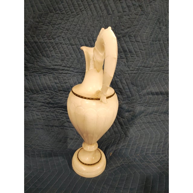 Circa 1870. Exceptional French ewer-form lamp carved in creamy alabaster, featuring a sculptural serpent-form handle with...