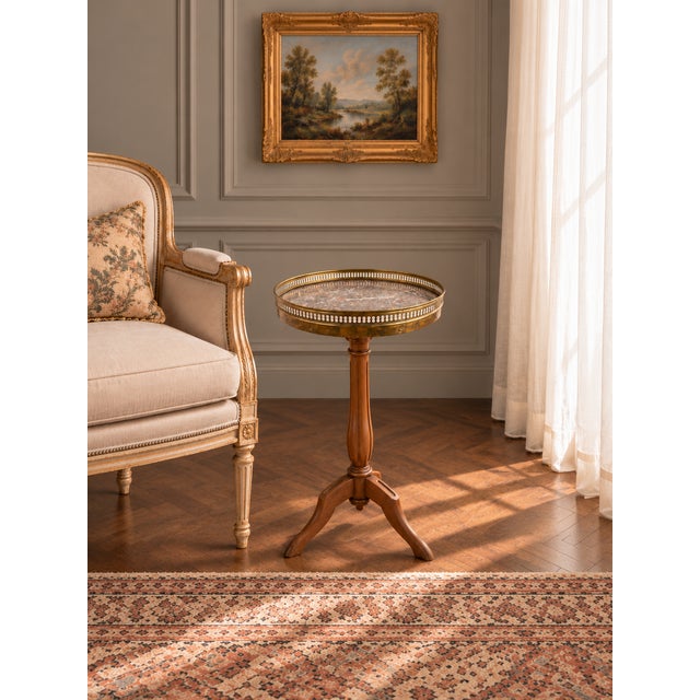 This vintage French gueridon side table features a beautifully veined marble top framed by a pierced brass gallery and...