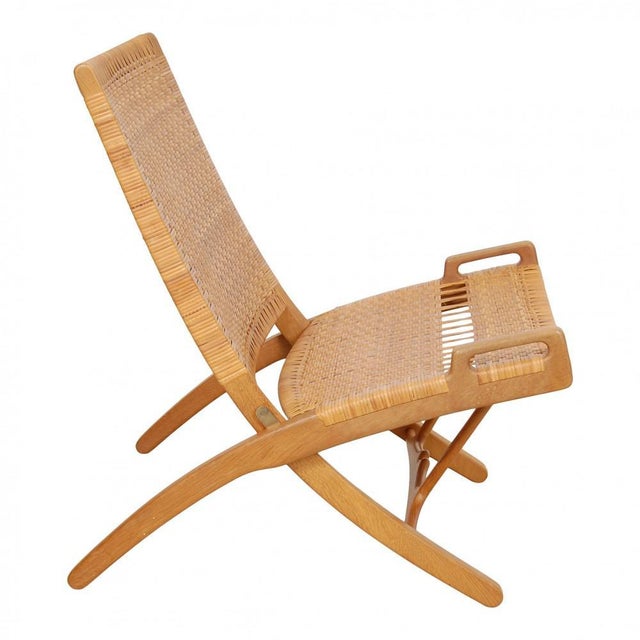Hans J. Wegner lounge chair model JH-512 with a seat and backrest of wicker, and frame of oak. The chair is from 1964 and...