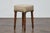 An English petite wooden stool from the 19th century with diamond top, turned legs and custom linen fabric. This petite...