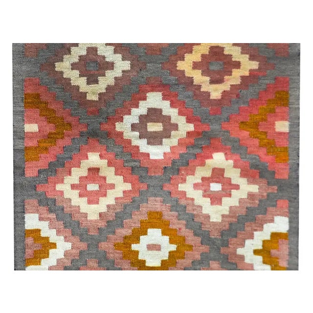 A wonderful vintage Afghani Kilim rug with an all-over diamond pattern woven in myriad colors including crimson, gold,...