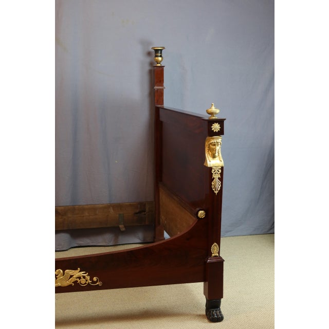 Rare empire period mahogany bed adorned with gilt bronze mounts and cassolettes on pilasters. This bed has been fully...