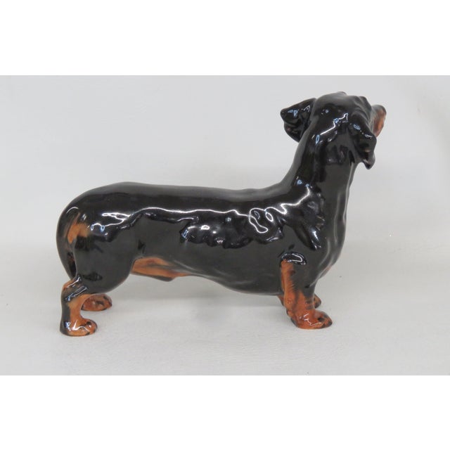 This vintage Royal Doulton Dachshund figurine is made of stunning porcelain for a timeless addition to any elegant...