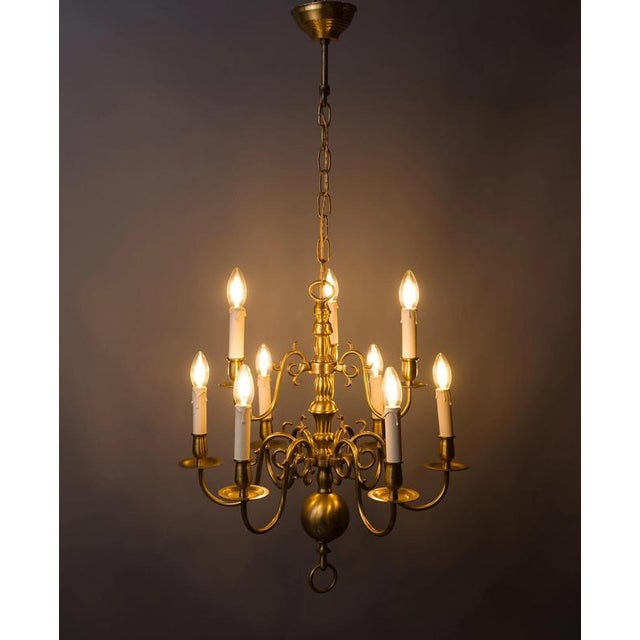 A classic brass chandelier with nine arms, made around 1950, in a high-quality cast design. The body of the chandelier...