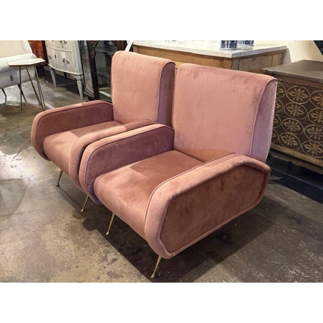 The product is a pair of elegant Mid-Century Modern Marco Zanuso lounge chairs upholstered in a pink velvet. These chairs...