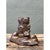 This vintage ceramic vase presents a charming figural composition, its cylindrical vessel disguised as a textured tree...