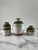 A set of three studio ceramic jars with attractive light gray and green striped glaze design. The containers have a terra...