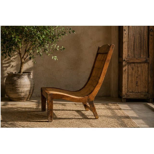 A striking ethnic lounge chair dating from the 1980s–1990s, handcrafted from exotic wood and finished with a beautifully...