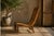 A striking ethnic lounge chair dating from the 1980s–1990s, handcrafted from exotic wood and finished with a beautifully...