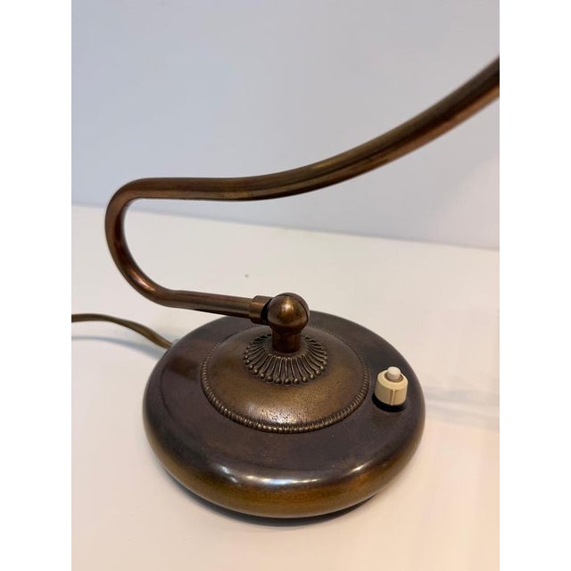 A beautifully designed vintage brass desk lamp featuring an elegant flowing arm and compact circular base. Its timeless...