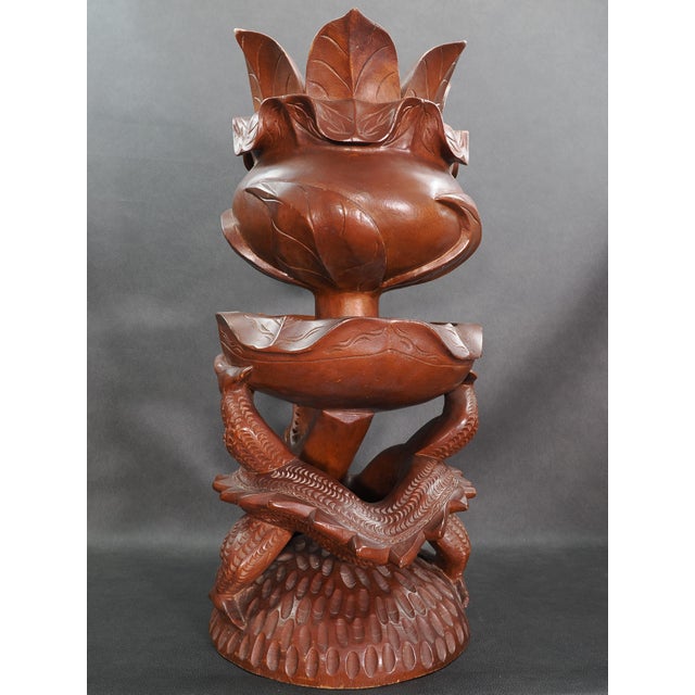 Carved from a single solid piece of wood, a dragon curls its body around to form the base of this sculpture, using its...