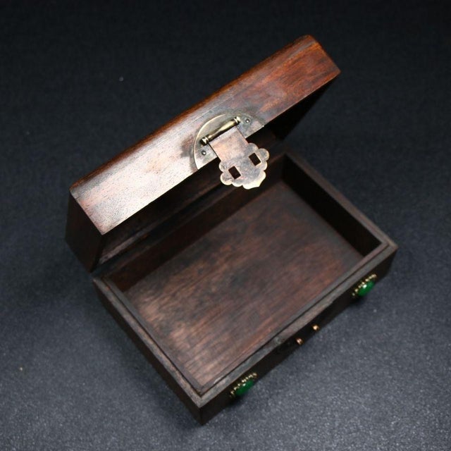 Handcrafted solid huali wood hinged jewelry box adorned with elaborate mother-of-pearl shell marquetry on the lid. The...