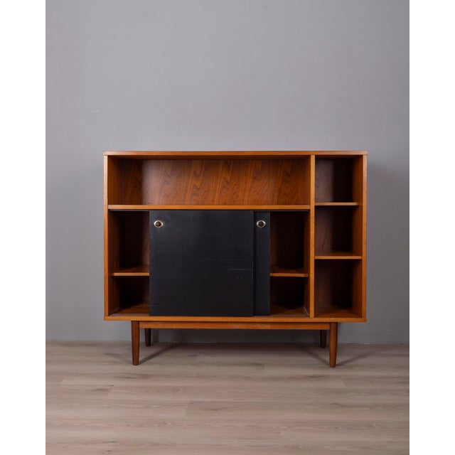Tall sideboard in teak wood with gold-plated brass inserts, the two central sliding doors are in black painted wood,...