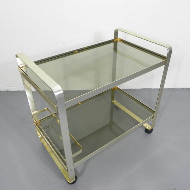 Height: 69 cm. Width: 70 cm. Depth: 43 cm. The serving trolley has some small scratches to the glass commensurate with its...