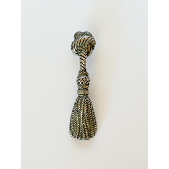 Charming silver toned bottle opener shaped like a knotted rope tassel. Why not make every day tools beautiful? It's chic...