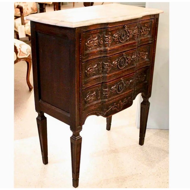 A small Italianate version of a leggy carved chest of drawers, with a faux marble painted top and a charmingly carved...