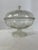 Single round clear glass footed compote serving dish with domed lid and acorn finial.