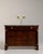 This 1860s Empire chest of drawers with marble top from France is built in richly figured flame mahogany beneath a dark...