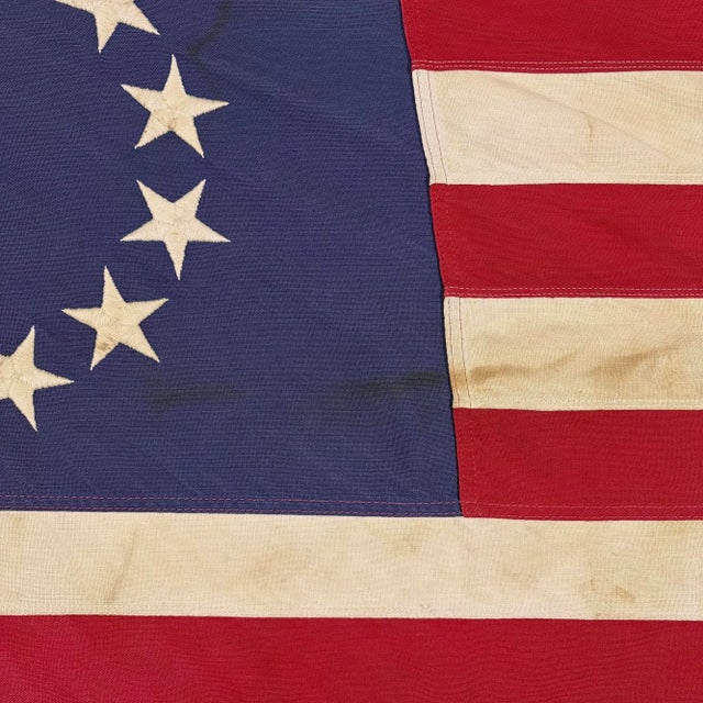 This vintage Betsy Ross American flag is made from a cotton cloth, with fully sewn stripes and 13 embroidered stars....