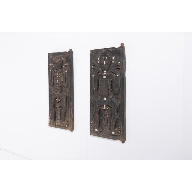 Mid-20th century African tribal pair of wood panels with a relief carving of a nude standing woman and man figures....