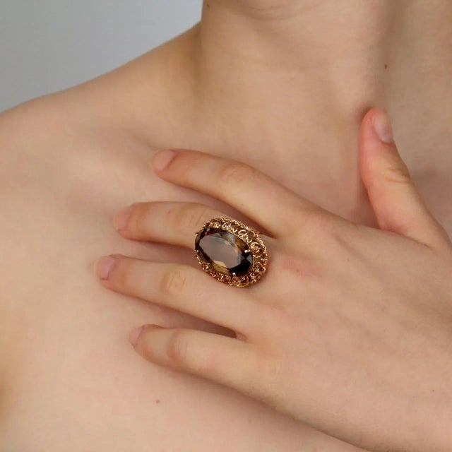 A very fine gold and citrine cocktail ring. With a large faceted oval citrine prong set in a openwork or filigree setting....