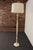 Beige floor lamp styled after Alberto Giacometti's "Tête de femme" design, though sculpted from resin, as opposed to...