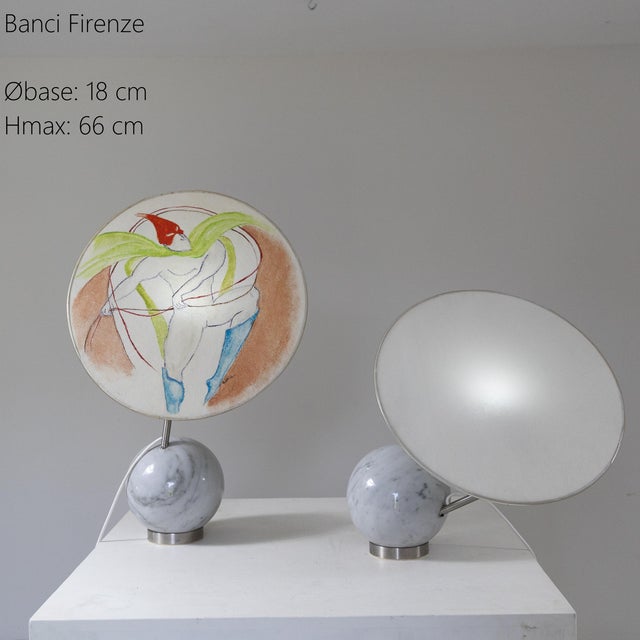 A pair of lamps with a small synthetic base supporting a white Carrara marble sphere. The idea is to tilt the spherical...