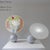 A pair of lamps with a small synthetic base supporting a white Carrara marble sphere. The idea is to tilt the spherical...