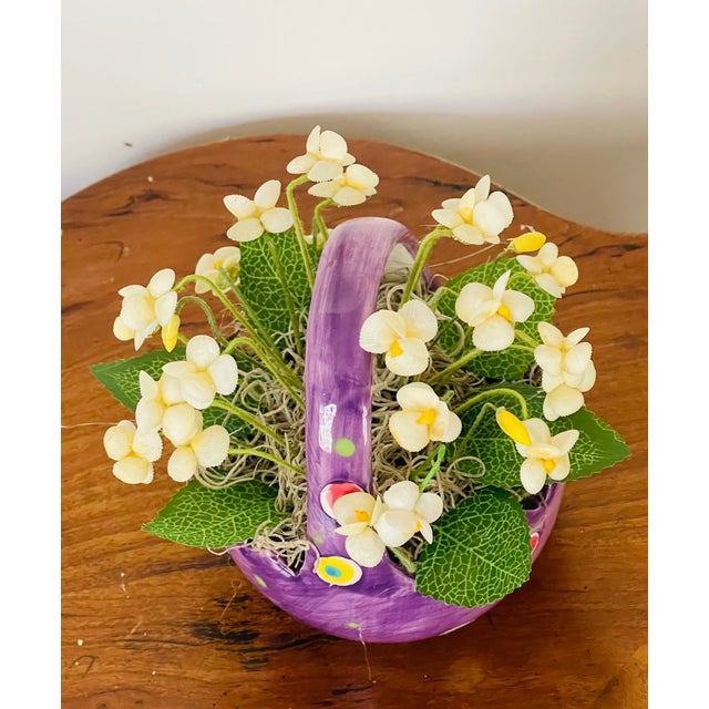 Elegant spring bouquet of sea shells white violets in an arrangement , on a small crystal dish stand.