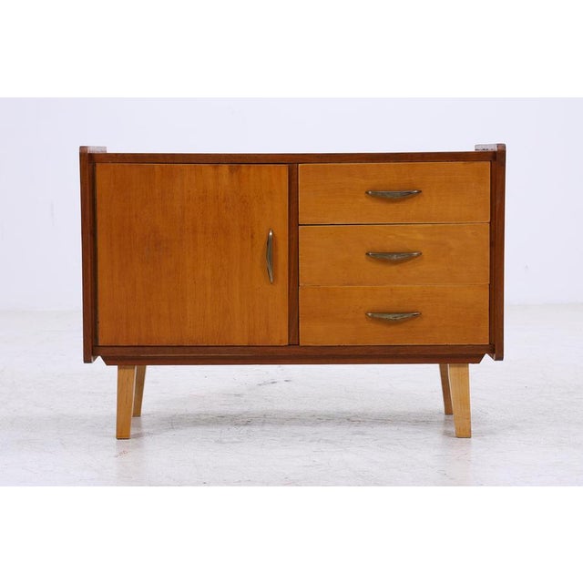 Beautiful vintage chest of drawers from the 60s with a clean, compact design and a calm wood finish. The door and drawers...