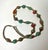 A colorful necklace featuring an assortment of lantern, barrel, bicone and spindle-shaped mosaic inlay beads. Turquoise-...