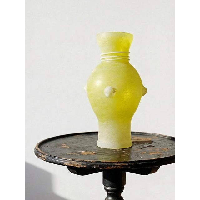 Elegant Murano glass vase with a scavo finish in a beautiful dark yellow hue. Its slender baluster silhouette is adorned...