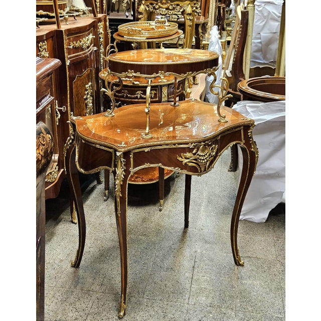 Enhance your interior with this elegant Louis XV style two-tier side table, featuring a beautifully shaped marquetry top...