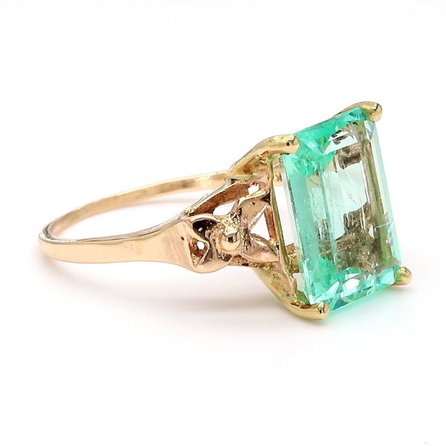 Vintage 14K yellow gold ring featuring a 3.58 carat emerald cut pastel light green Colombian emerald set in a 4-prong...