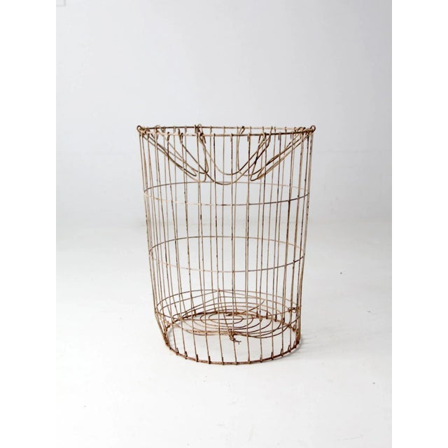 This is a vintage wire basket. The industrial metal storage basket features a wire frame with hinged wire loops as top...