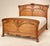 A period Art Nouveau double bed, circa 1895-1910, in solid mahogany and mahogany veneer with a slightly wavy satinwood...