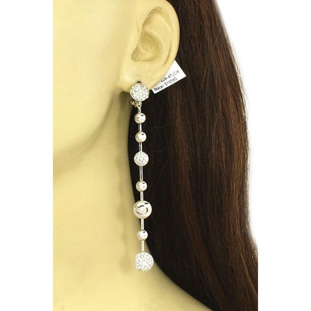 This is a new never worn pair of designer Koesia 18k gold and diamonds ladies dangle earrings. The pair is well crafted in...