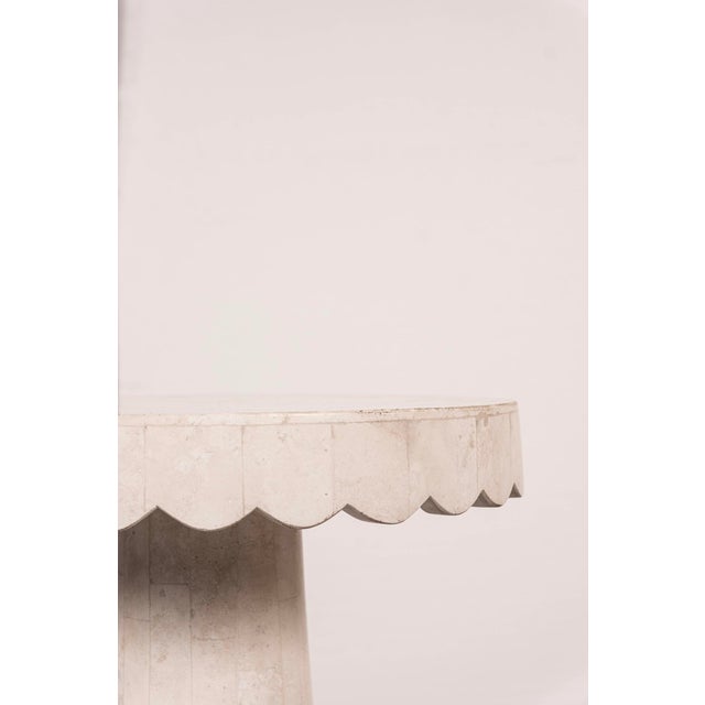 Natural white tessellated stone table with scalloped edge and gilt base detail. Not labelled.