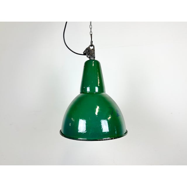 Industrial green enamel pendant light made by Polam Wilkasy in Poland during the 1960s. White enamel inside the shade....