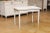 A Swedish Gustavian style painted wood table from the late 19th century, with carved rosettes and tapered legs. Created in...