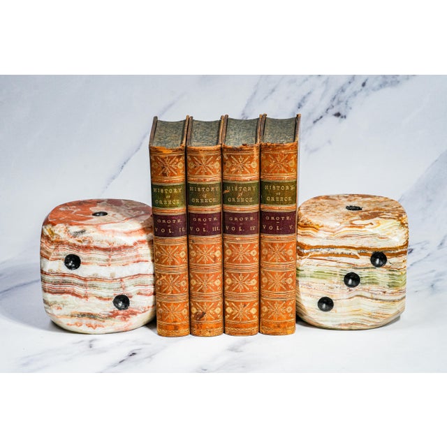 This striking pair of oversized dice is carved from beautifully banded onyx marble, showcasing dramatic natural striations...