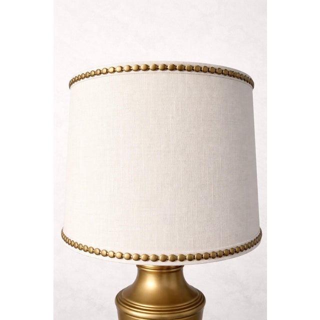 This refined pair of vintage solid brass table lamps features classic urn-form bodies with stepped bases and warm original...