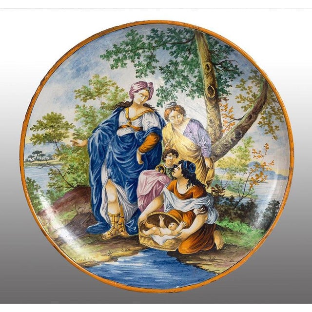 An antique ceremonial plate in polychrome glazed majolica depicting Moses being saved from the waters, dating from the...