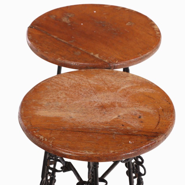 An exceptional pair of artist-made stools, likely from France, handcrafted from forged iron and solid oak. The sculptural...