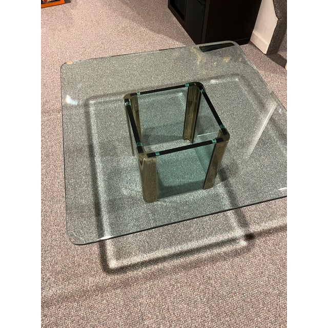 Beautiful addition to room. Glass and brass Leon Rosen cocktail table. 36 inch glass top, 16inch brass and glass base. The...