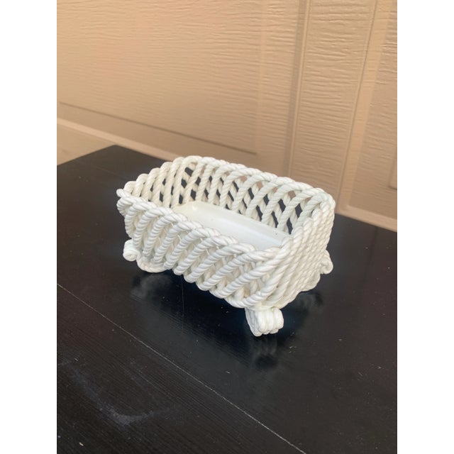 An elegant trompe l'oeil porcelain cachepot crafted in the form of a handwoven rope basket. Executed in glossy white...