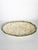An elegant oval glazed ceramic platter, featuring a delicate, slightly raised pattern of overlapping leaves. The cream-...